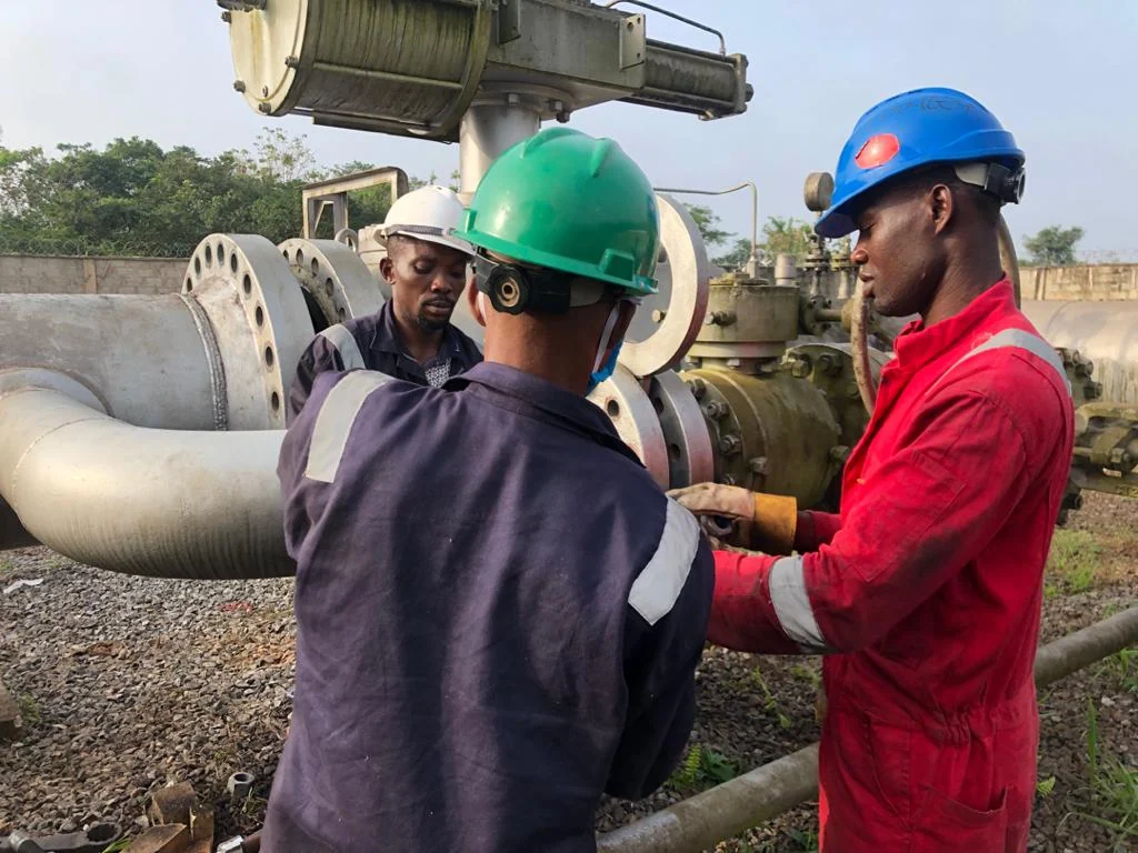 Technicians inspecting pipeline equipment during commissioning