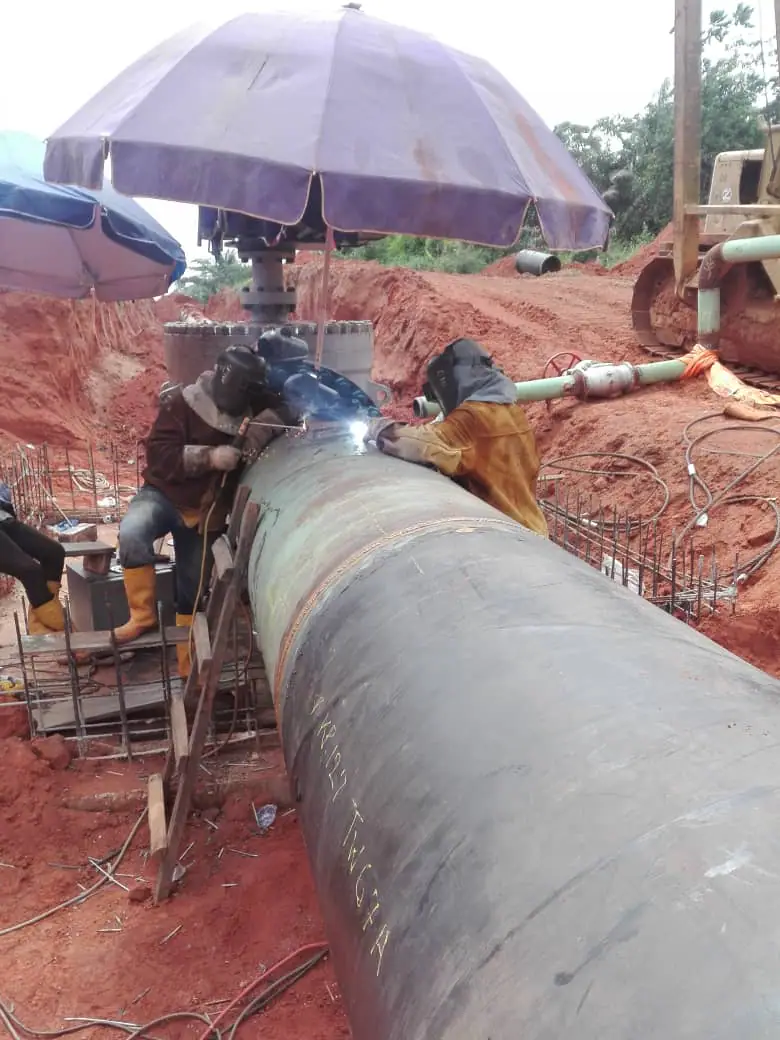 Welders completing a field girth weld on a large-diameter pipeline