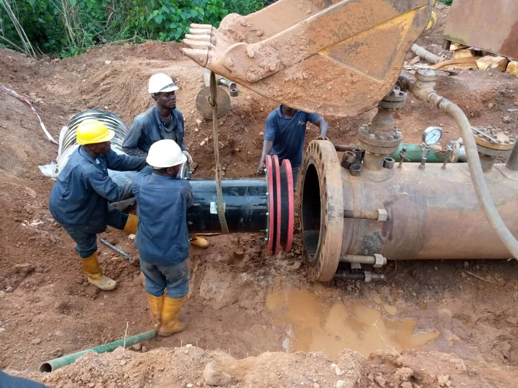 Technicians aligning a pipeline fitting during field installation